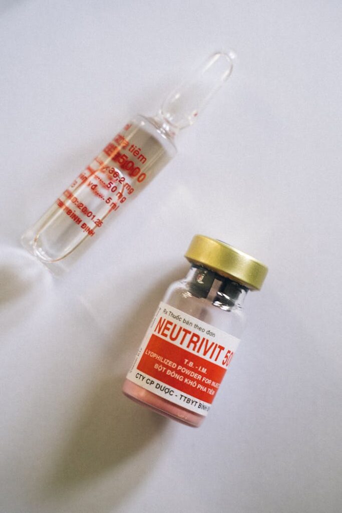 Flat lay of healthcare ampule and medicine bottle on a white background.